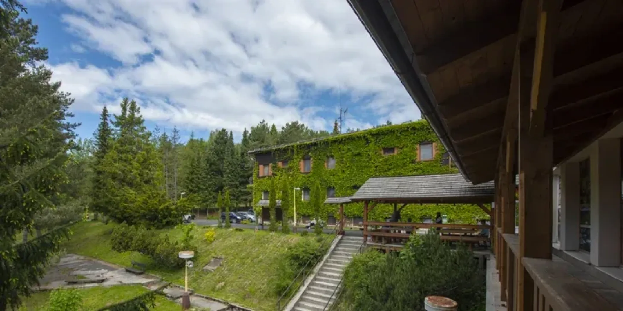 The green, plant-covered façade of the Predná Hora guest house in its mountain resort