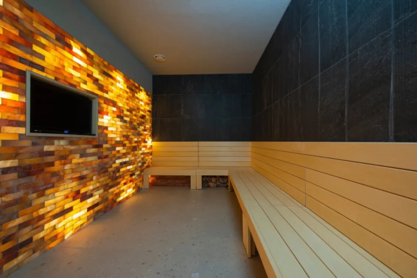 The salt cave, with a wall of backlit salt bricks and wooden benches along the walls