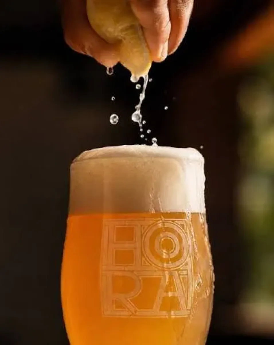 A glass of unfiltered Predná Hora beer with the head spilling over