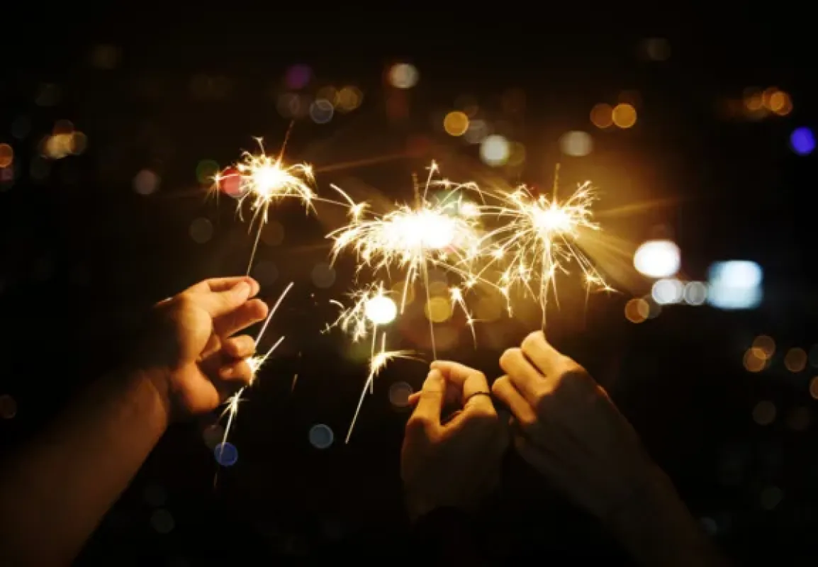 Sparklers in the hands of guests at a New Year’s Eve party